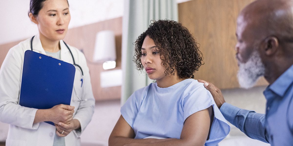 Female doctor talking to woman with father
