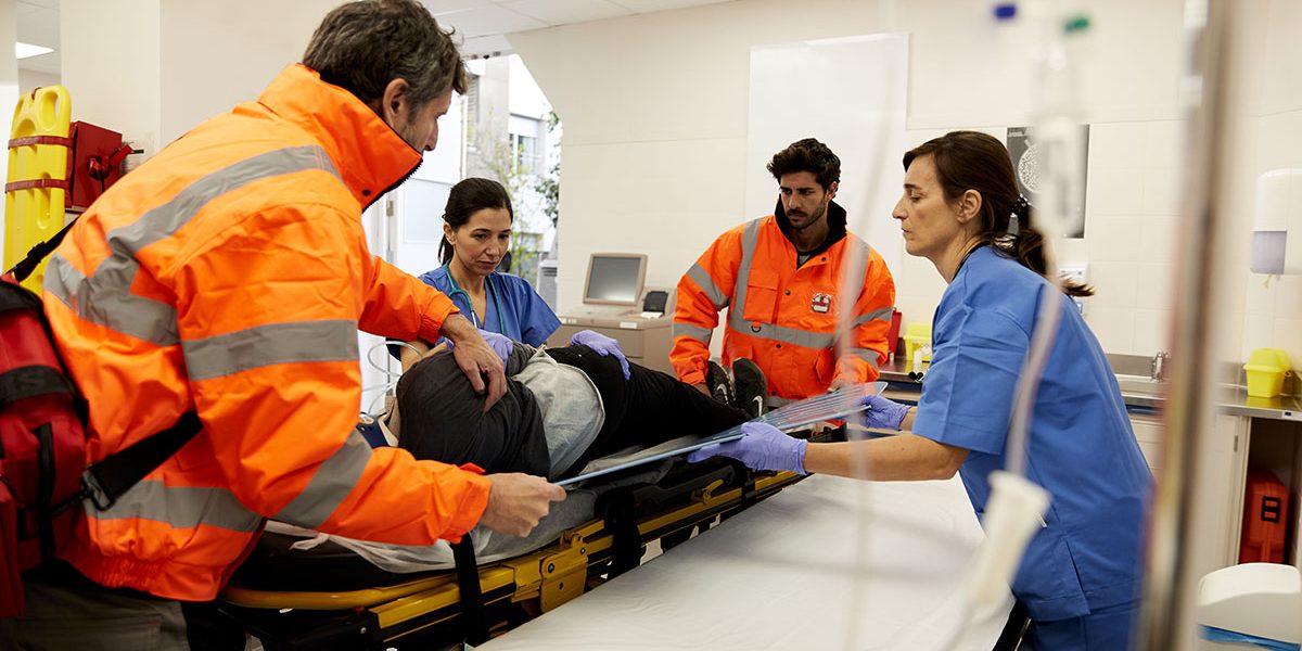 Hospital health care and medicine. Ambulance and emergency.
Group of medical workers transferring a patient from the hospital gurney to the stretcher